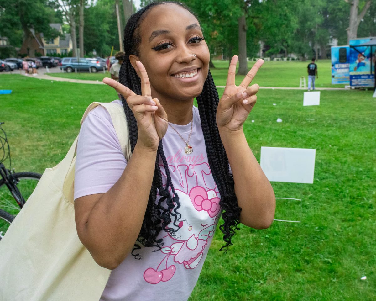 Young woman flashing peace signs at a park fundraiser
