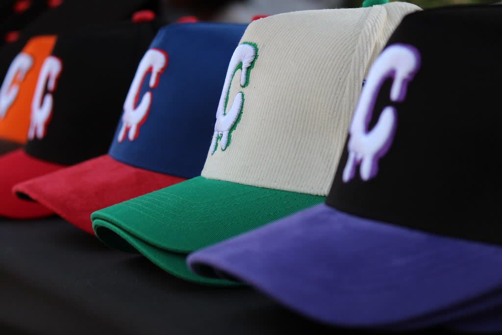 Row of embroidered caps at a merch table