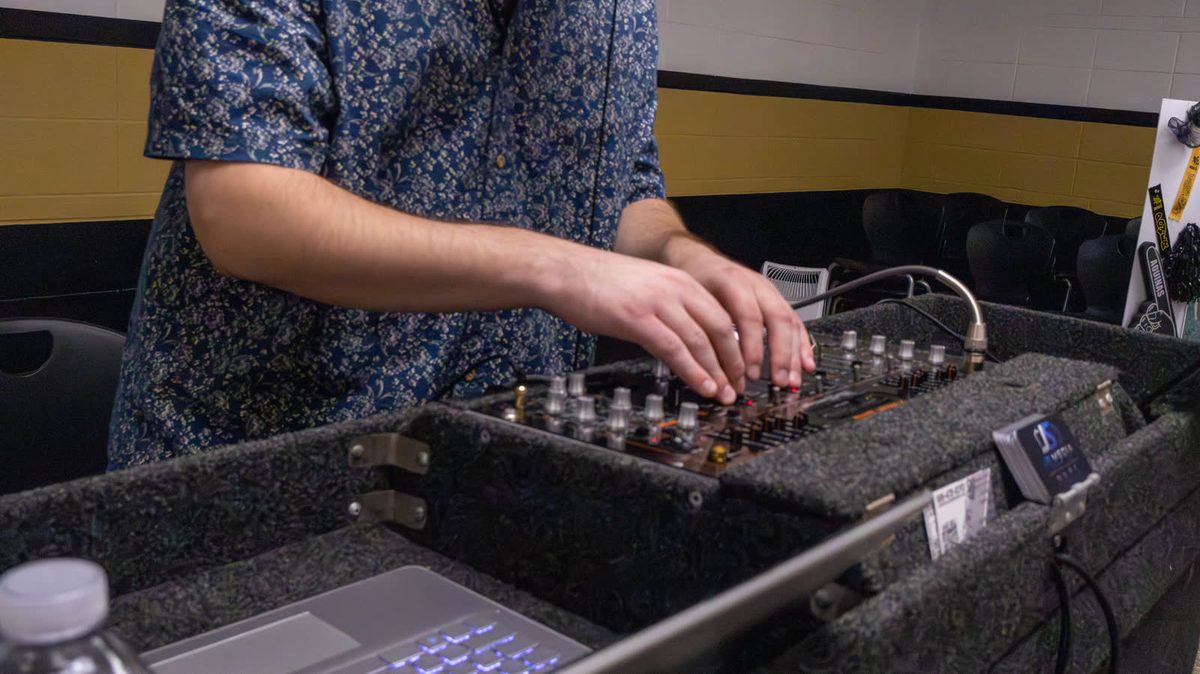 Hand adjusting a mixing board in the studio
