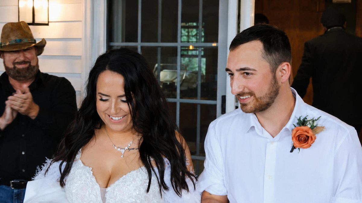 Bride and groom smiling as they walk into their reception